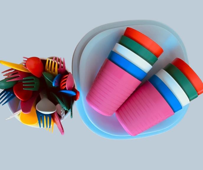 overhead view of colourful plastic plates, cups and cutlery