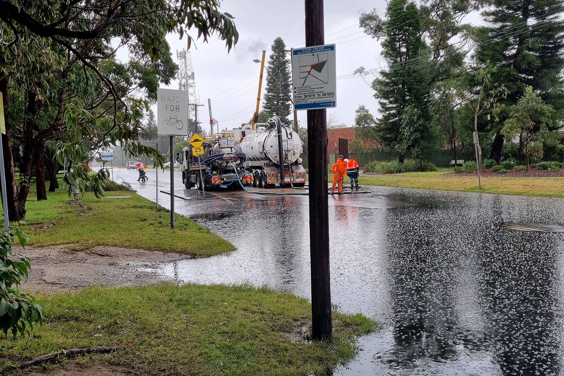 Oily floodwaters on street in Kurnell, with cleanup truck