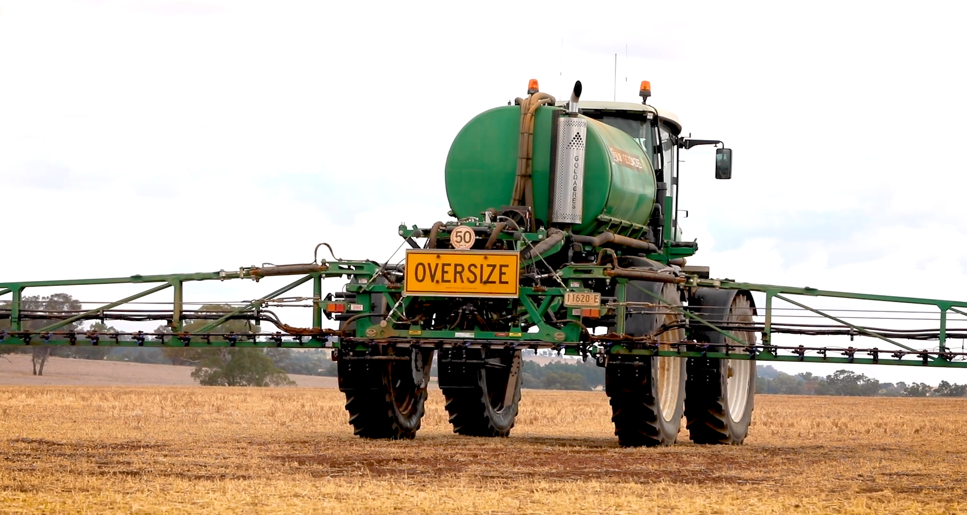 Pesticide spray unit from rear with spray arms extended