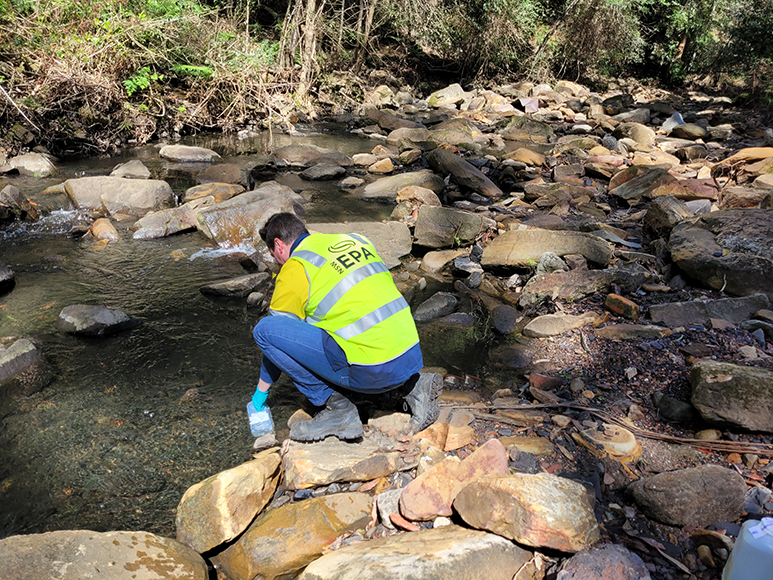 An EPA officer sampling water in Camp Gully Creek